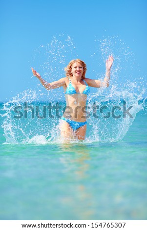 happy woman splashing the sea water