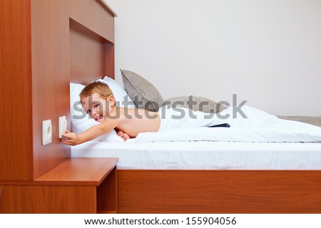 happy kid ready to sleep in bedroom, turning off the light