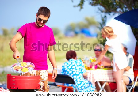 Happy Man Cooks Vegetables On The Grill, Family Picnic