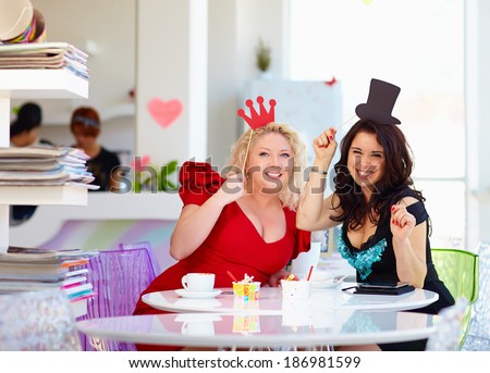 plus size women friends enjoying life, having fun in cafe