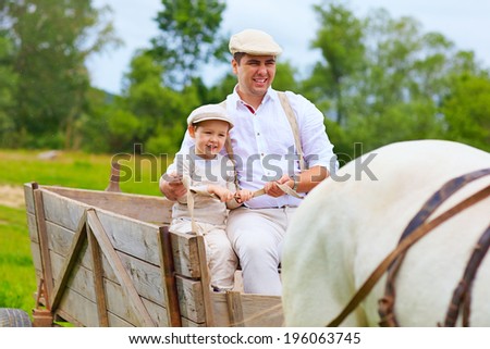 father and son ride a horse cart