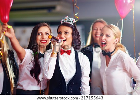 group of girls friends having fun on karaoke party