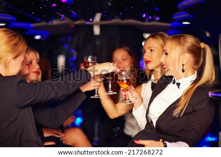 beautiful women clinking glasses in limousine