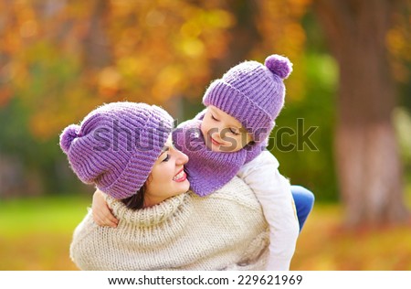 happy mother and son playing in autumn park