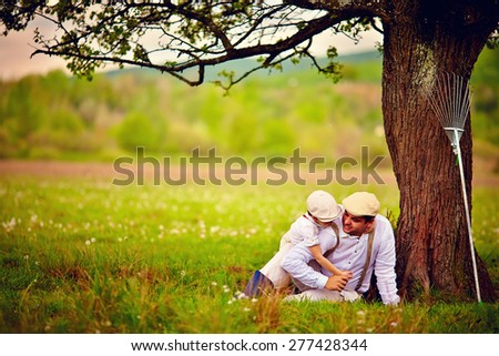 happy father and son playing together under an old tree