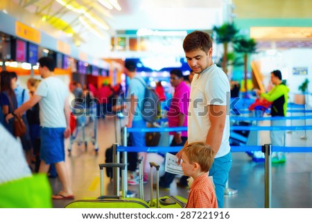 family standing in queue at passport control check in international airport