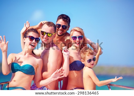 group of happy friends, family having fun on yacht, during summer vacation