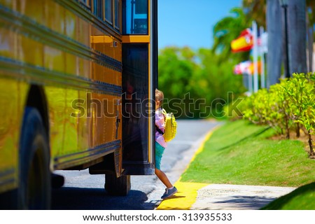 young boy, kid getting on the school bus, ready to go to school