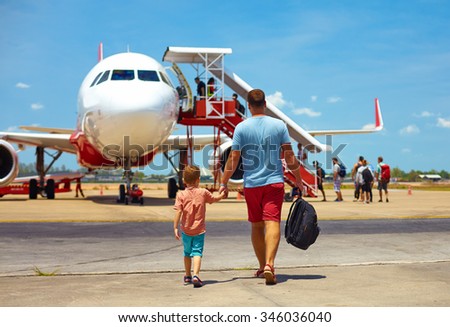 family walking for boarding on plane in airport, summer vacation