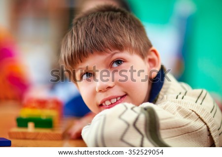 portrait of young smiling boy, kid with disabilities