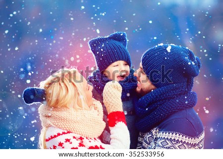 happy family having fun under winter snow, holiday season