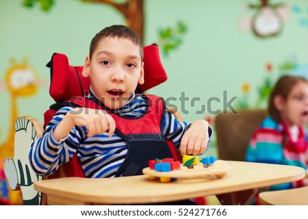 cheerful boy with disability at rehabilitation center for kids with special needs