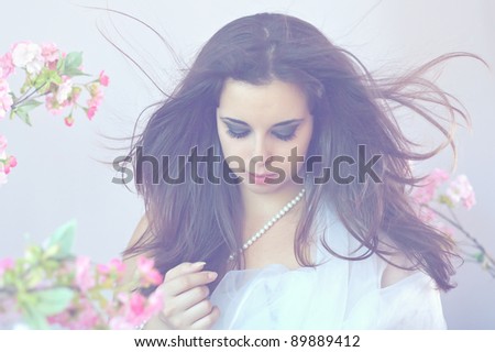close-up tender portrait of attractive plump  woman with fluttering hair on flower background