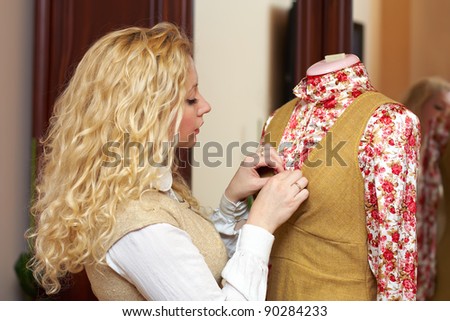 Portrait of woman, fashion designer, dressmaker working with tailoring mannequin at home studio