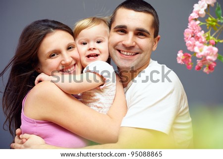 happy family of three persons embracing