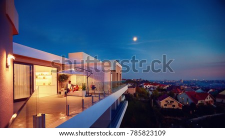 family relaxing on roof top patio with evening city view