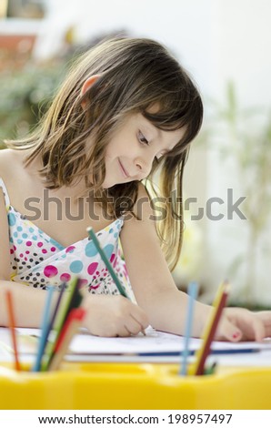 Beautiful smiling little  girl drawing and daydreaming at home - education, creation and school concept