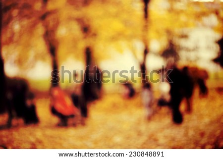 Natural bokeh background of  people walking in an autumn park. Intentional motion blur.