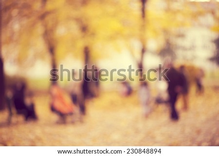 Natural bokeh background of  people walking in an autumn park. Intentional motion blur.