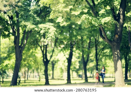 Defocused background of park in spring or summer season, blurred people walking, retro colors