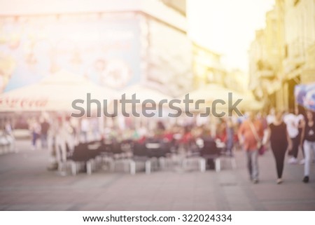Blurred crowd of walking people in the city with buildings in the background