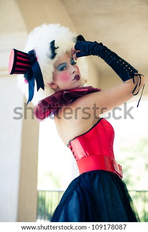 Beautiful Woman with heavy party makeup wearing a corset and Black gloves