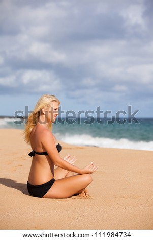 Beautiful Woman sitting in the Quiet of the Beach ending Meditation with Namaste