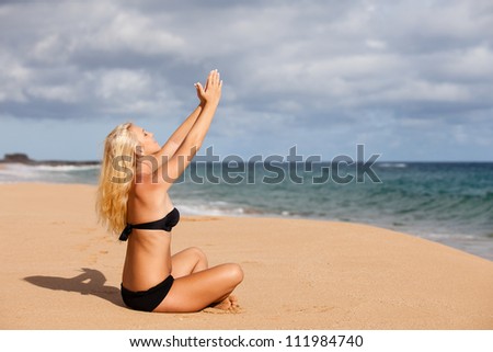 Sun tanned Blonde sitting in the Quiet of the Beach in Prayer