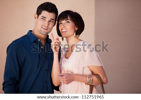 Beautiful Woman and Handsome Man looking out of the frame pointing