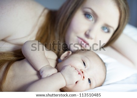 Cute Baby looking at camera with Mom in background