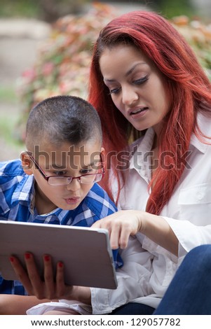 Mother and son together on Mother\'s day reading from a touch pad