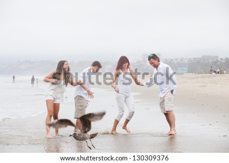 Attractive family with teens having fun on the beach at Santa Monica Ca as a bird flies by