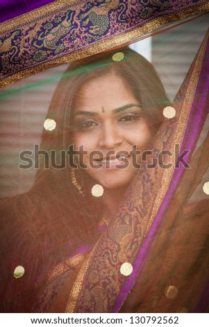 Close up Portrait of a Beautiful Asian Woman framed by her scarf smiling