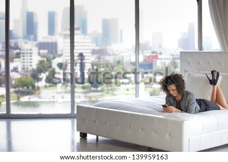 Beautiful Business Woman in a Penthouse Suite at a Hotel on her cell phone