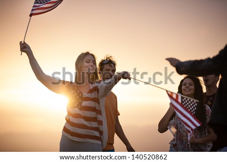 Group Of Friends In Their Twenties Dancing On The Beach At Sunset In California