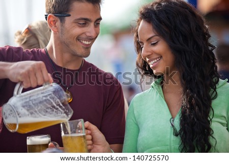 Attractive Man pouring a beer at an outside cafe on the Beach in Venice California