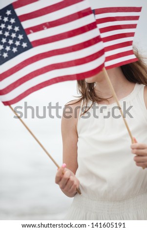 Beautiful Teen Girl with American flags walking on the Beach in Malibu