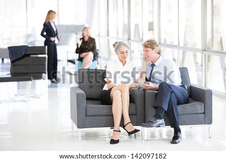Attractive Mature Couple enjoying music together on a Mini Pad at the Airport