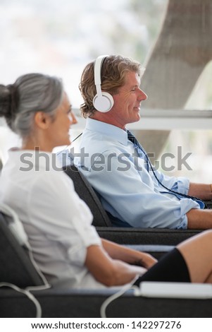 Attractive Mature couple listening to music on Headsets