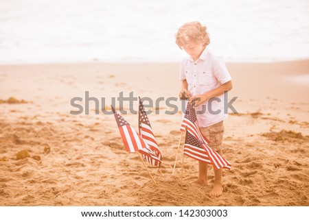 Attractive boy with American Flag on the beach after loosing his first tooth