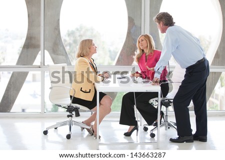 Mature business people discussing an idea around a laptop computer