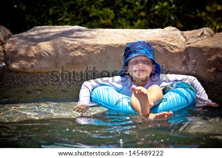 Young boy floating in a inner tube  eyes closed in a blissful state