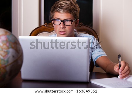 High school student studying at night at the kitchen table
