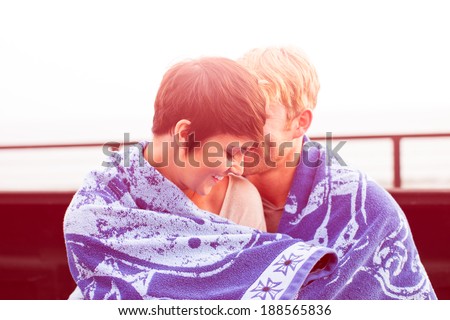 Attractive Young Couple at Sunset sitting in a truck bed at the beach in California