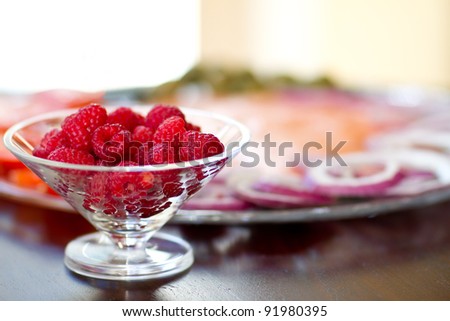 Fresh Raspberries in front of a fresh Lox, onion tomato Plate