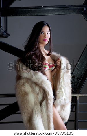 Beautiful Young Woman with long hair wearing a Faux fur coat
