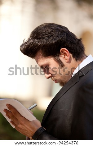 Handsome Guy in a Business Suit Signing Documents