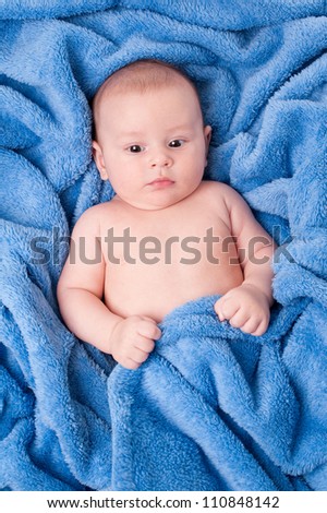 Happy little child wrapped in blue towel