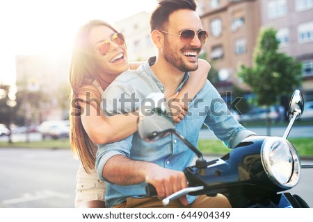 Couple in love riding a motorbike. Handsome guy and young sexy woman travel.
