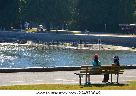 VANCOUVER - JULY 27: People at Stanley Park Seawall on July 27, 2014in Vancouver Canada. Famous seawall where park visitors walk, bike, roll, and fish on the 22 kilometers seawall route.
